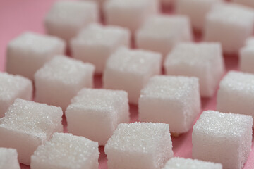 Sugar cubes on pink background