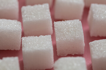 Sugar cubes on pink background