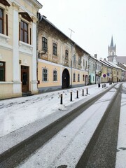 Fototapeta premium Evangelical Church Tower in Bistrita in january 2022,and the flag of Romania ,view from Nicolae Titulescu street