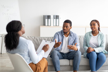 Young black couple on meeting with marital counselor, working on their relationship at psychologist's office