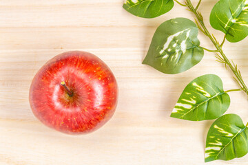 Naklejka premium A Red Apple Fruit on A Wooden Cutting Board, Autumn or Fall Background, Cooking Image
