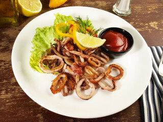 Octopus, Fried Calamari Rings with Salad on a Plate with Chili Sauce and Lemon