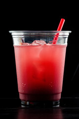 Red drink cocktail or lemonade with ice in a glass