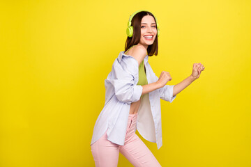 Photo of cool bob hairdo young lady dance wear headphones green singlet shirt isolated on yellow background