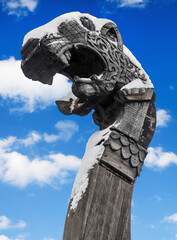wooden dragon head on Drakkar on winter blue sky background