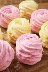 Delicious pink and yellow marshmallows on wooden board, closeup