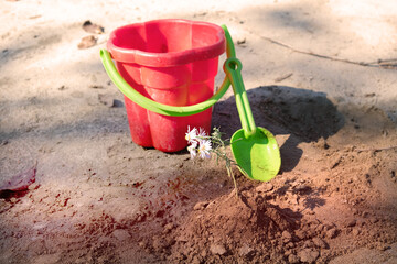 Childrens red bucket and shovel, summer leisure games on the beach