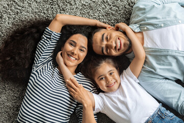 Closeup portrait of happy middle-eastern family cuddling on floor