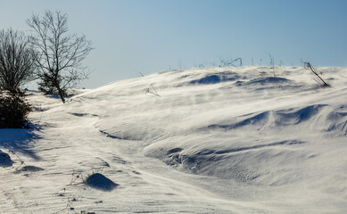 Blizzard. Wind blowing snow over the hill 