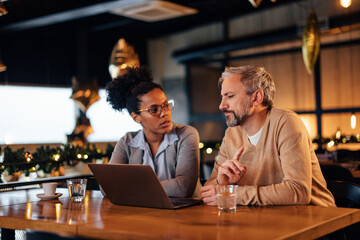 Serious caucasian man, talking to his african-american colleague.