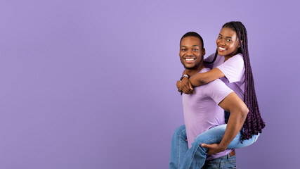 African American man giving piggyback ride for his lady