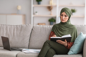 Modern Muslim Businesswoman Reading Notebook With Work Schedule Indoor