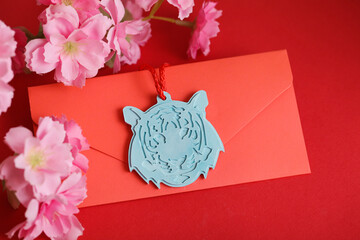 Chinese New Year 2022 decoration Blue Tiger, Red Envelope on red background. Flowers of good fortune.