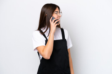 Restaurant Brazilian waiter woman isolated on white background keeping a conversation with the mobile phone with someone