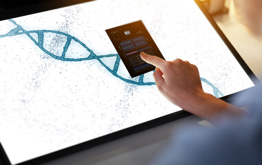 technology, science and genetics concept - hand on led light tablet or touch screen with dna...