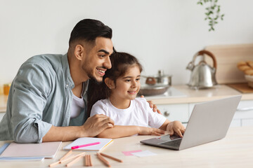 Happy arab single father helping daughter with homework