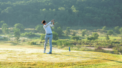 Golfer sport course golf ball fairway.  People lifestyle man playing game golf tee off on the green grass.  Asian man player game shot in summer.  Healthy and Sport outdoor