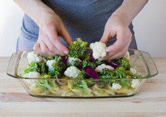 Woman cook delicious homemade meal from vegetables cauliflower, broccoli, onion
