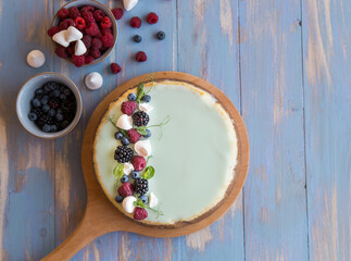 Traditional whole sliced cheesecake on a  blue wooden background.