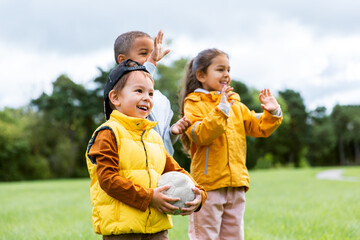 Fototapeta premium childhood, leisure and people concept - group of happy children with soccer ball at park