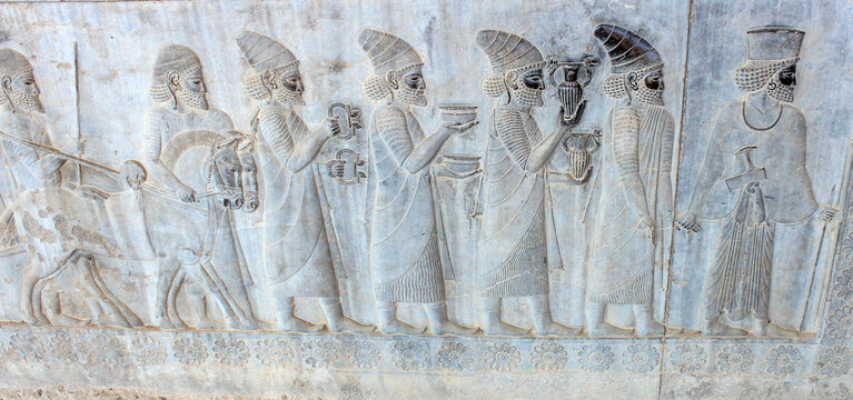 Ancient wall in Persepolis with bas-relief with Phoenician people with gifts and donations for Persian king