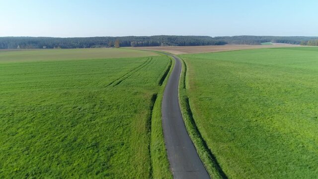 Small country road through meadows and agricultural fields, Germany