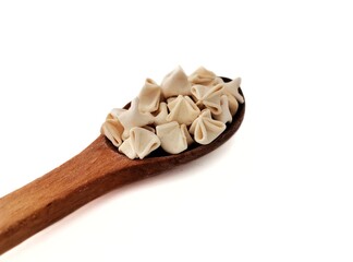 Ravioli in a wooden spoon.