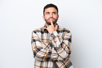 Young Brazilian man isolated on white background having doubts while looking up