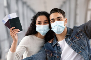 COVID-19 Travels. Happy Arab Couple In Medical Mask Taking Selfie In Airport