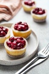 Mini cheesecake with cherry jam. One bite dessert. Tiny cheesecakes with berry. Valentine homemade present. Selective focus.