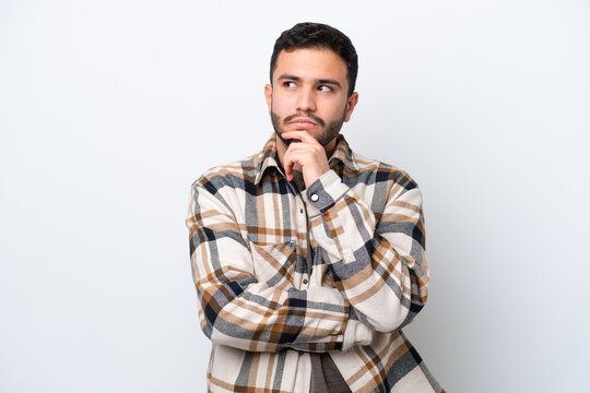 Young Brazilian man isolated on white background having doubts and thinking