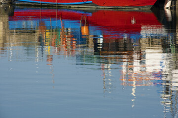 Fototapeta na wymiar reflection of a fishing boats in the port of Portimao. Algarve, Portugal