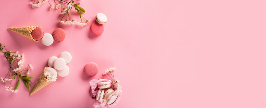 Rose sweet cookies macaroons in gift box and Cherry blossoms on pink background.