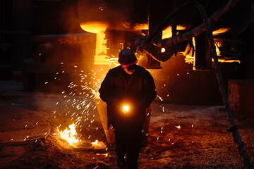 Metallurgist steelmaker takes a sample of liquid metal from a ladle. Ingot casting. Steel...