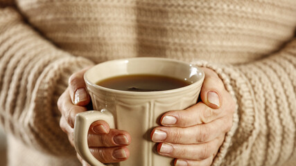 Hot tea in mug and woman hands 