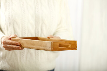 Wooden tray of free space and woman hands. 
