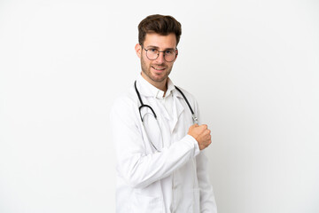 Fototapeta premium Young doctor caucasian man over isolated on white background wearing a doctor gown and making victory gesture