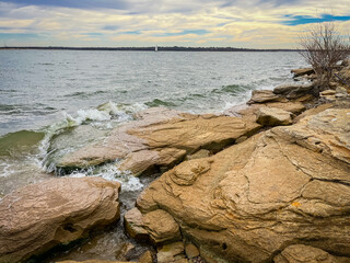 High waves over sandstone cliff along rocky shoreline and dropoffs at Murrell Park in North side of...