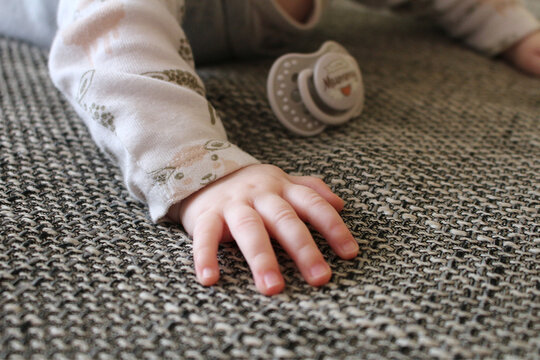 Detail of young baby hand with dummy