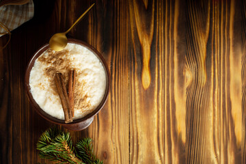 Delicious rice pudding with cinnamon in bowl on wooden background