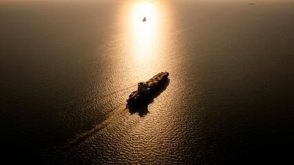 Silhouette Container ship full load carrying for import and export, business cargo logistic and transportation by container ship in open sea over the sunlight background, © SHUTTER DIN