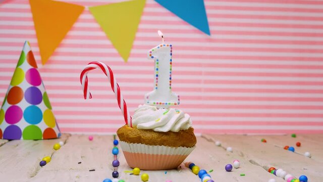Happy birthday greeting for 1 year old baby, beautiful happy birthday video background for 1 year old on pink background with cream cupcake and candle with fire