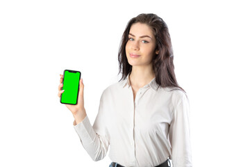 Woman wearing a white shirt holding a smartphone (with green screen) looking at camera. Isolated on white background. 20-22 years old. White european woman.