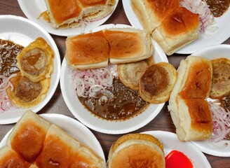 Sauth asian food chicken bun kabab,daal kabab, double bun kabab, french fries, patraroti With Tomato Sauce and Spicy Chutney in white plate top view food table
