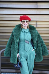 Fototapeta premium Elegancka kobieta w futerku w kolorze butelkowej zieleni. 