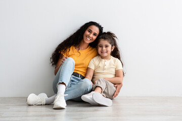 Happy Middle-Eastern Mother And Little Daughter Sitting On Floor Smiling At Camera