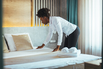 Maid making bed in hotel room. Housekeeper Making Bed. Maid making bed in hotel room. Staff Maid...