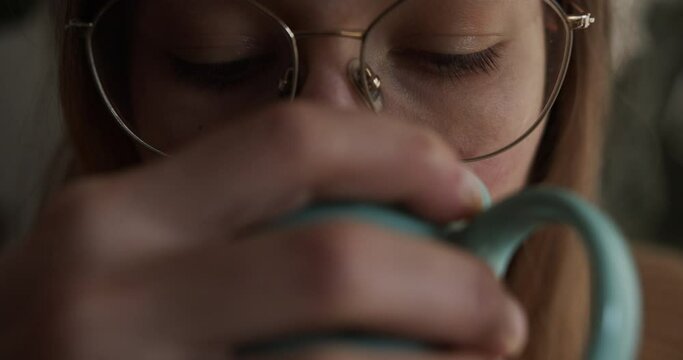 CLOSE UP: Woman drinks her coffee and enjoys her morning