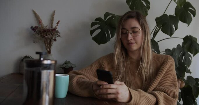Girl sit down on table and takes her phone