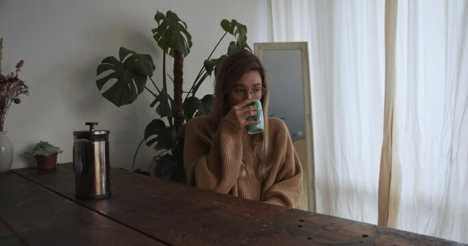 Woman has her morning coffee in her moody appartement